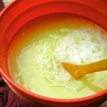 Orange 5-gallon bucket filled with homemade laundry soap