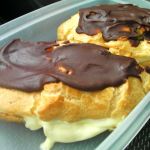 Container with two chocolate glazed cream eclairs