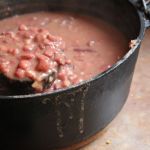 A black cast iron dutch oven full of red beans