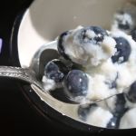 Half view of cup filled with blueberries and frozen milk