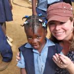 Woman holding the hand of a Haitian child