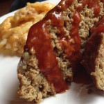 Plate with two slices of meatloaf, glaze dribbling over sides