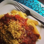 White plate on teal background showing pasta primavera