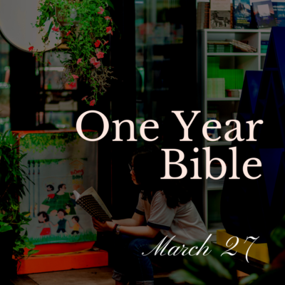 Woman sitting outside in front of a building reading a Bible