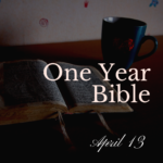 An open Bible on a table with a blue mug with heart logo